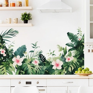 Detail of tropical monstera leaves and pink flowers wall decal on white kitchen wall