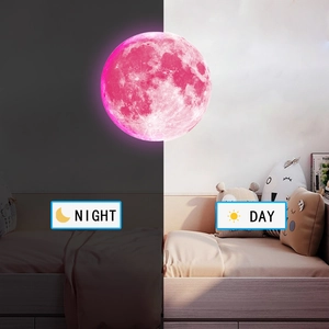 Glow-in-the-dark moon wall decal showing pink lunar texture in day and night contrast