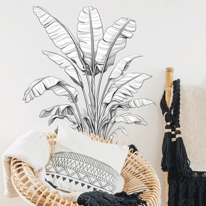Detail of minimalist black and white banana leaf wall sticker in a boho living room decor