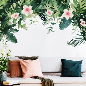 Tropical wall stickers with palm leaves and hibiscus flowers over a gray sofa