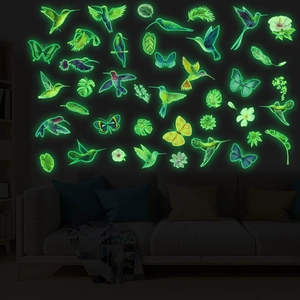 Luminous hummingbird and tropical leaf wall stickers glowing in a dark room setting