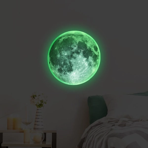 Luminous moon wall sticker showing detailed craters and green glow in a dark bedroom