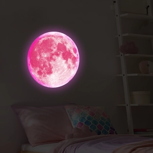 Close-up of pink luminous moon wall sticker with realistic crater texture for kids room