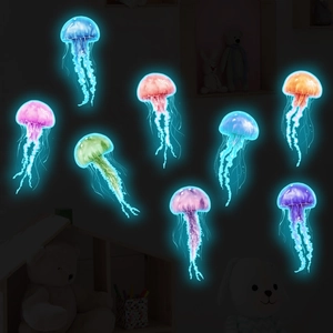 Luminous jellyfish wall decals showing blue and pink glowing effects in a dark bedroom