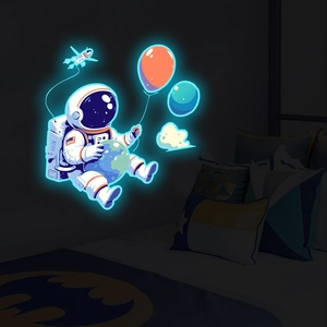Glow-in-the-dark astronaut wall sticker glowing in a dark bedroom setting