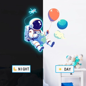 Luminous astronaut wall sticker showing day and night glowing effect in a kids bedroom