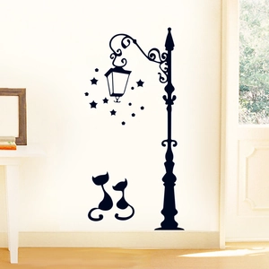 Detail view of retro street lamp and black cat wall stickers in a cozy home setting
