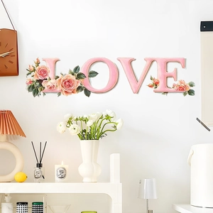 Detailed pink LOVE letter wall stickers with floral rose accents on a white wall