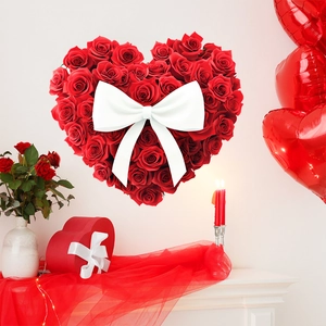 Detail of wall decoration featuring a heart-shaped red rose wreath with a white satin bow