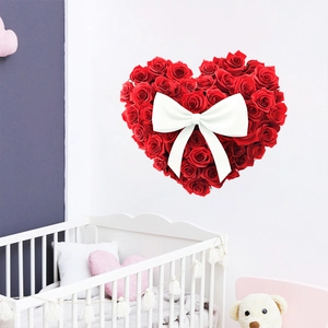 Detail of red rose heart wall sticker with white silk bow on a clean white background