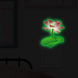 Luminous lotus flower wall sticker glowing in dark over a light switch panel