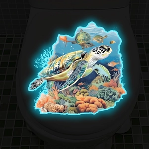 Luminous sea turtle toilet decal glowing in dark bathroom with coral reef theme