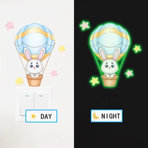Sticker mural lumineux montrant l'effet fluorescent jour et nuit du lapin en montgolfière