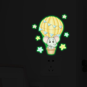 Sticker mural phosphorescent avec éléphant en montgolfière jaune et étoiles décoratives