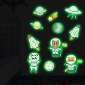 Close-up of glowing solar system and astronaut animal wall stickers in a dark room