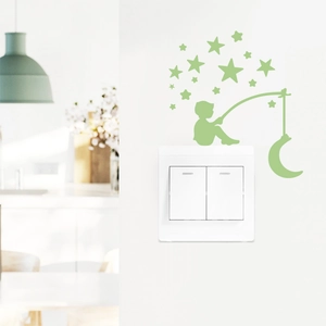 Glow in the dark wall sticker featuring a boy fishing the moon and stars on a switch