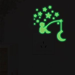 Luminous wall sticker showing a boy fishing the moon and stars in dark room