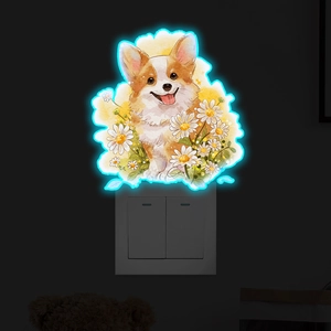 Sticker mural corgi lumineux avec marguerites installé au-dessus d'un interrupteur