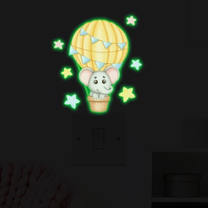 Sticker mural phosphorescent avec un petit éléphant en montgolfière au-dessus de l'interrupteur