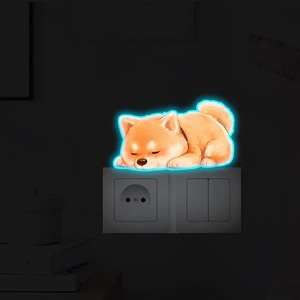Autocollant mural Shiba Inu phosphorescent au-dessus de l'interrupteur dans le noir
