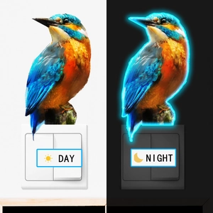 Luminous kingfisher wall sticker showing day and night glow effects on light switch