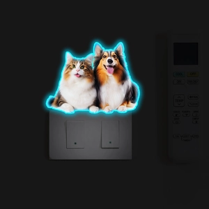 Luminous pet wall stickers with cat and dog silhouettes glowing on a wall switch