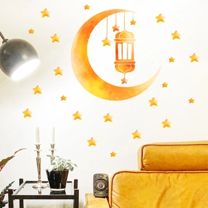Luminous blue watercolor moon and stars wall stickers for home decor in a living room