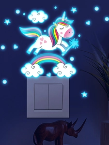 Luminous unicorn and rainbow wall stickers glowing blue on wall near light switch