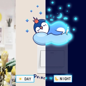 Luminous penguin wall sticker showing day and night blue fluorescent effect for home decor