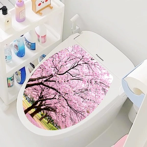 Close-up of waterproof pink cherry blossom stickers on a white modern toilet lid