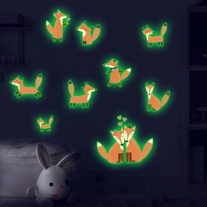 Detailed view of green glowing fox wall stickers illuminating in a dark children's room