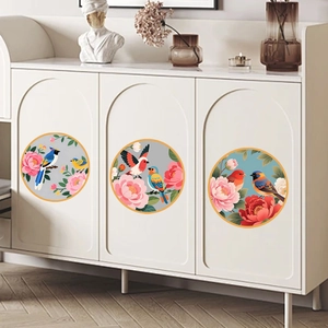 Three circular wall stickers with Chinese bird and flower motifs on a white cabinet door