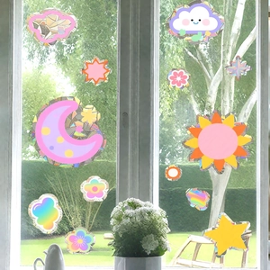Holographic sun and moon window stickers creating rainbow light on glass window