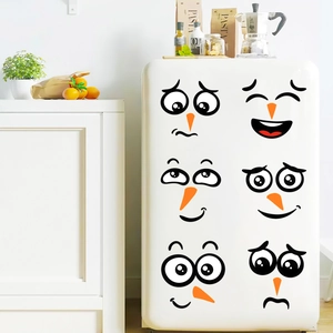 Detail view of cute snowman face decals applied to a white refrigerator for holiday decor