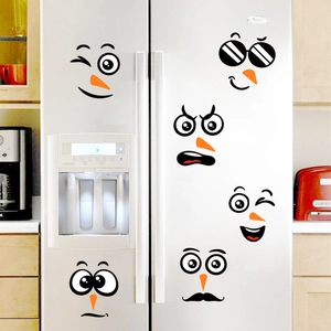 Detail showing various cute snowman face stickers applied on a white modern refrigerator