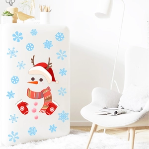 Close-up of Christmas snowman PVC stickers with red hat and snowflakes on a white fridge