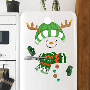 Close-up of festive Christmas snowman stickers applied on a white kitchen refrigerator