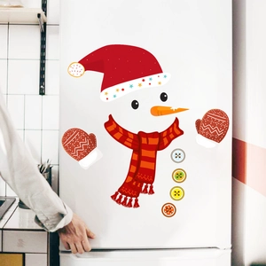 Close-up of cute Christmas snowman decals including a red hat and scarf on a white fridge