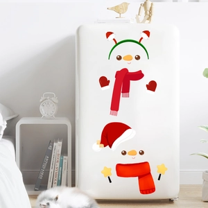 Detail of Christmas snowman stickers with red scarves and hats on a white refrigerator surface