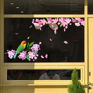 Detail of colorful bird and pink flower window sticker on a glass surface