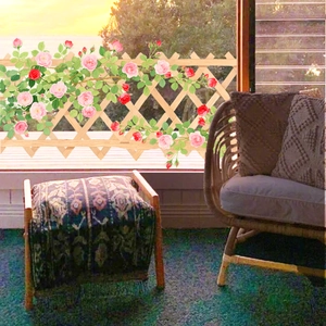 Detail of wooden trellis fence with artificial pink roses for home window decor