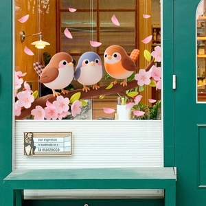 Detail of static glass stickers showing cartoon birds on cherry blossom branches for windows
