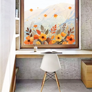Detail of static autumn floral window clings with orange flowers and maple leaves on glass