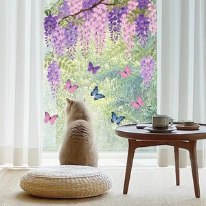 Detail of purple wisteria and butterfly static stickers on a bright glass window