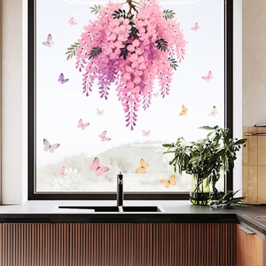 Detail of pink wisteria flowers and colorful butterfly window stickers on a kitchen window