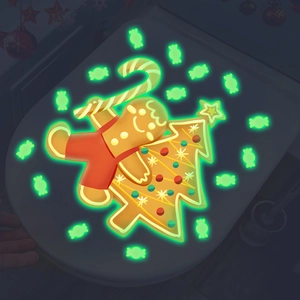 Glow in the dark Christmas gingerbread man and tree sticker on toilet lid in darkness