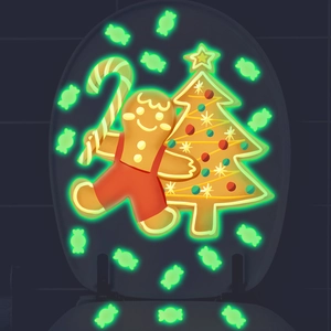Luminous Christmas gingerbread and tree stickers glowing on a toilet lid in the dark