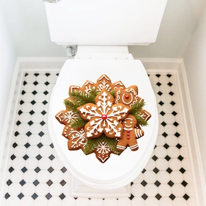 Close-up of gingerbread man and snowflake stickers on a white toilet lid for Christmas