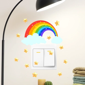 Close-up of rainbow and glowing star wall stickers around a light switch panel