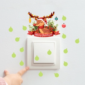 Close-up of luminous reindeer wall sticker with Merry Christmas banner on a white light switch